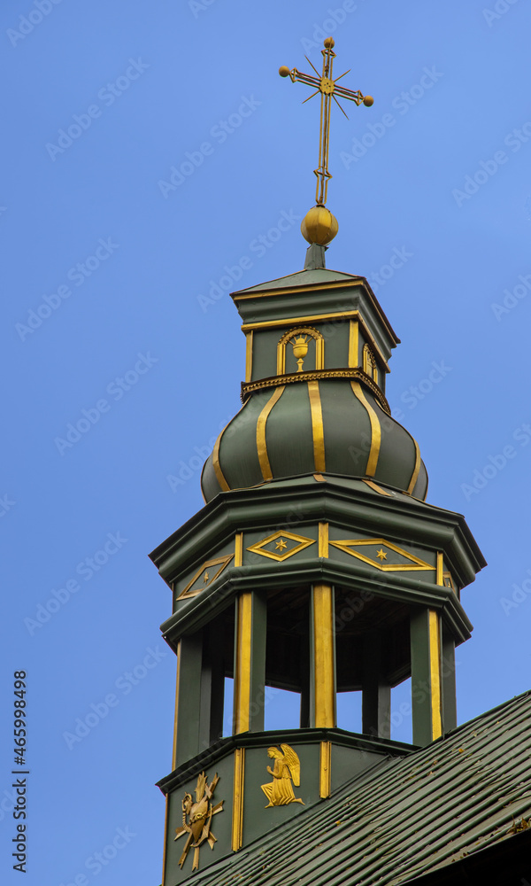 Built in 1839, a brick neo-Gothic belfry and a wooden church under the invocation of St. James the Apostle in Góra in Masovia in Poland. Photo: general view of the temple and close-up of architectural