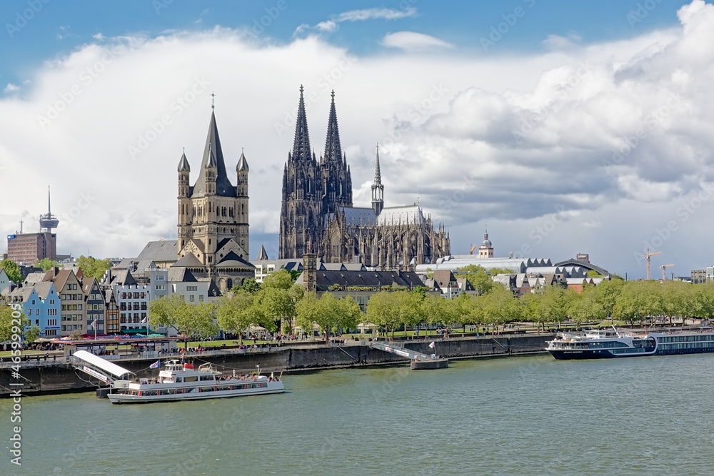 Towers of Cologne cathedral, and great saint Martin church and medieval houses on the embankment of river Rhine, Cologne, Germany