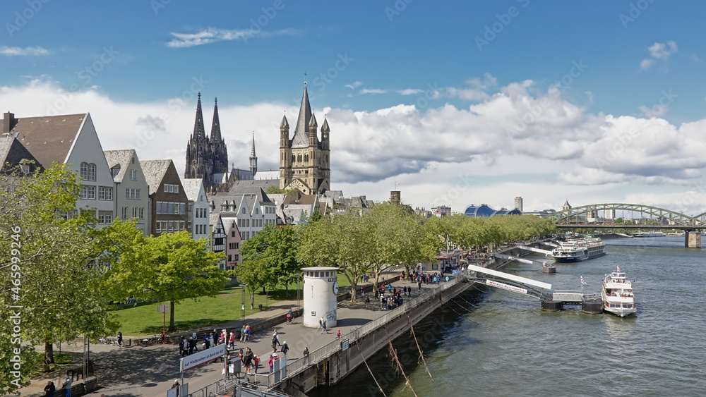 Quay along river Rhine with towers of the Cathedral and great Saint martin church and medieval houses in Cologne