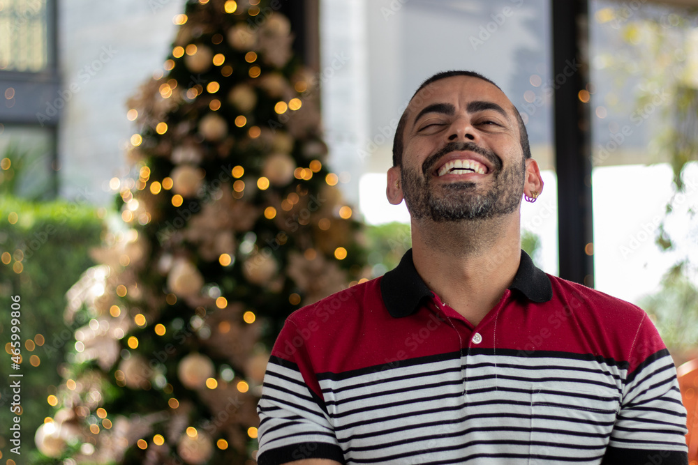 Portrait of an excited, happy young man in the background. Christmas decoration, Christmas day, Merry Christmas Portrait of an excited, happy young man in the background. Christmas decoration, Christmas day, Merry Christmas