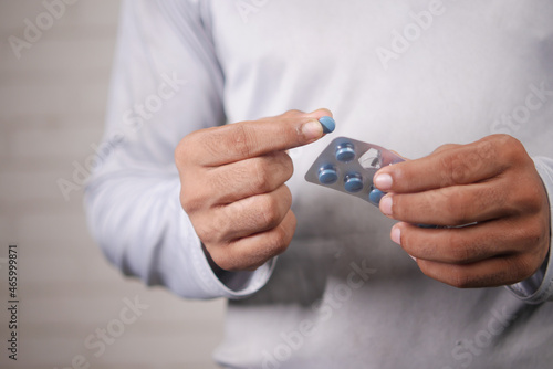 young man hand holding blister packs taking medicine 