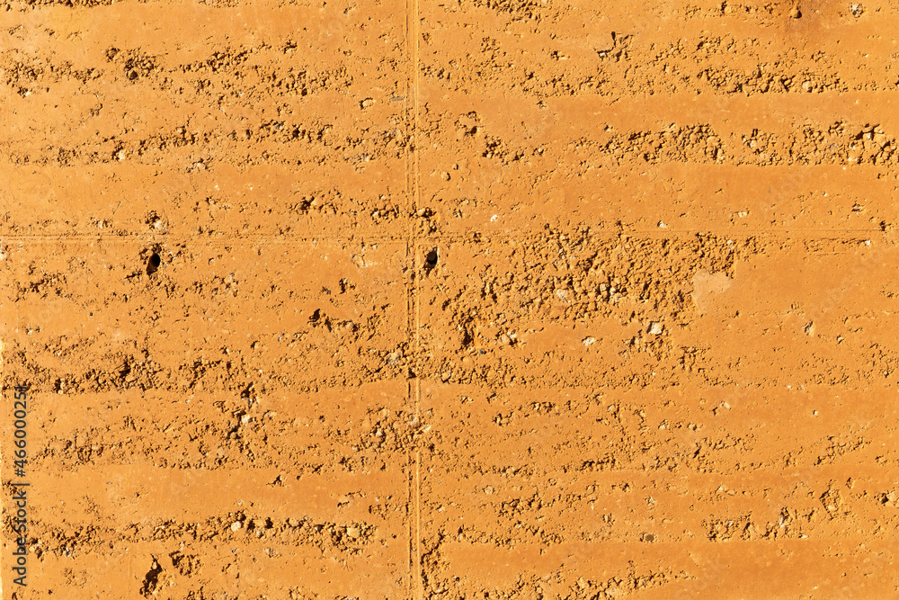 Rammed earth, an old building technique used to create the walls of a house by pressing sand into blocks. Sustainable and ecological textured material to build with. Future concept for housing - obrazy, fototapety, plakaty 