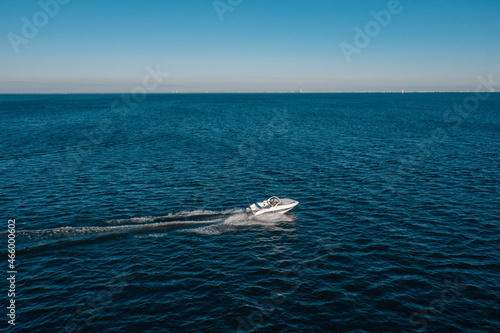 Canvastavla A view from a height of a white speedboat sailing in the birch sea