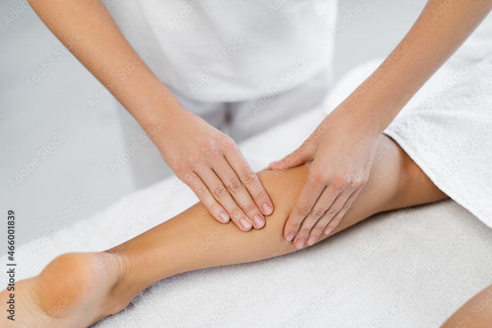 cropped view of professional masseur doing foot massage to client in spa center cropped view of professional masseur doing foot massage to client in spa center