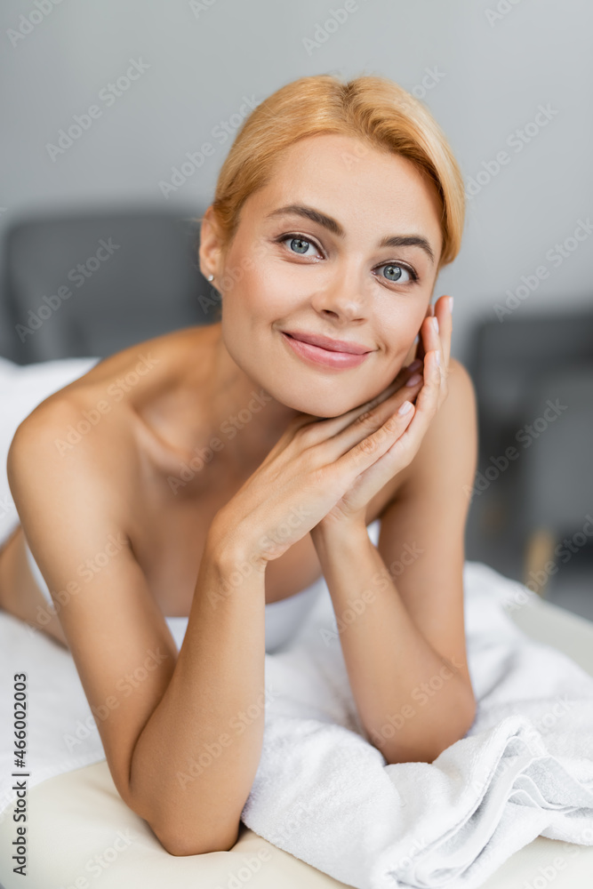 Fototapeta premium smiling and blonde client lying on massage table