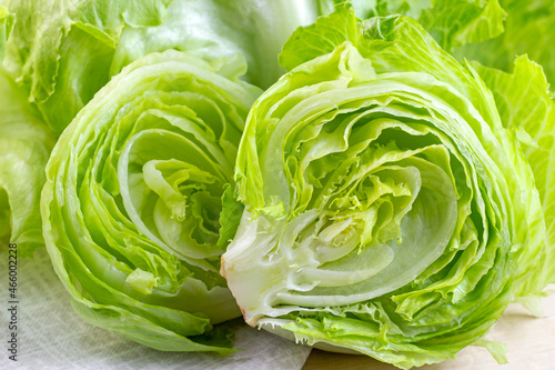 Fresh green iceberg lettuce salad leaves cut on light background on the table in the kitchen. photo