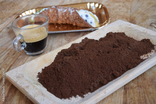 espresso coffee  with a cannolo and gound coffee photo