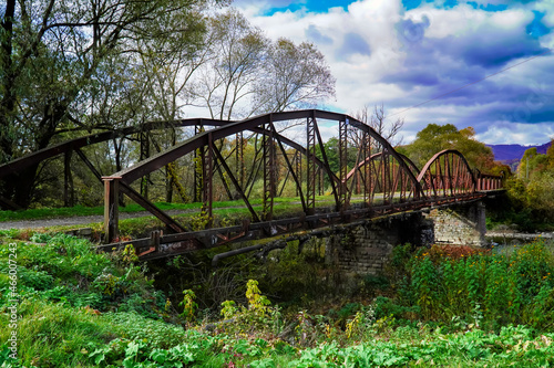 old bridge, road to the past, history, autumn bridge against a background of blue clouds 