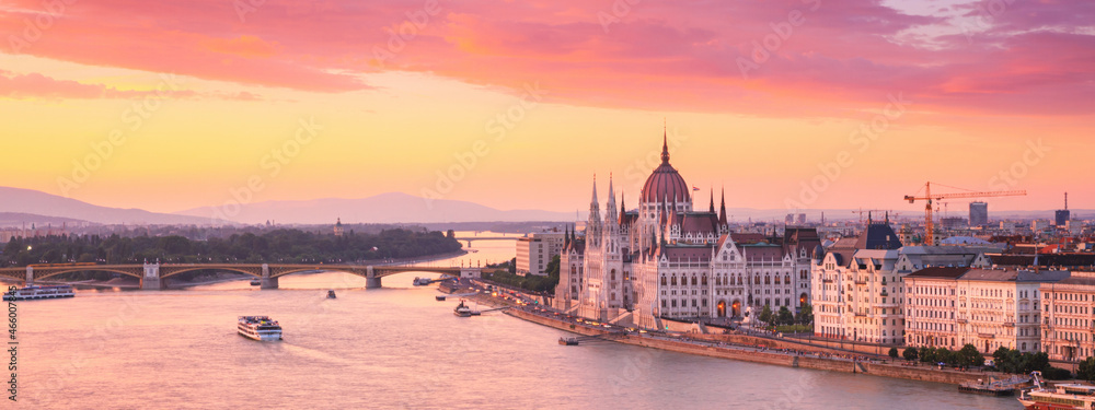 Obraz premium City summer sunset landscape, panorama, banner - top view of the Hungarian Parliament Building and Danube river with Margaret Bridge in the historical center of Budapest, in Hungary