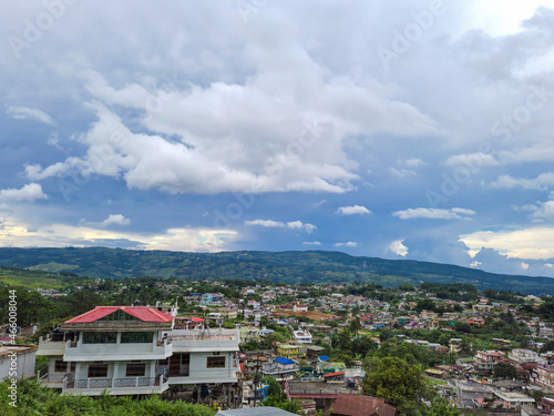 city urbanization view with mountain range at background at morning from flat angle © explorewithinfo