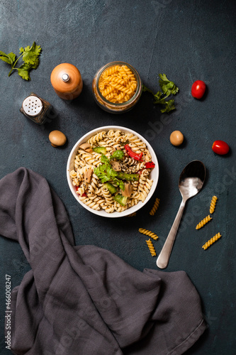 Home-cooked fusilli with cherry tomatoes on a navy blue background