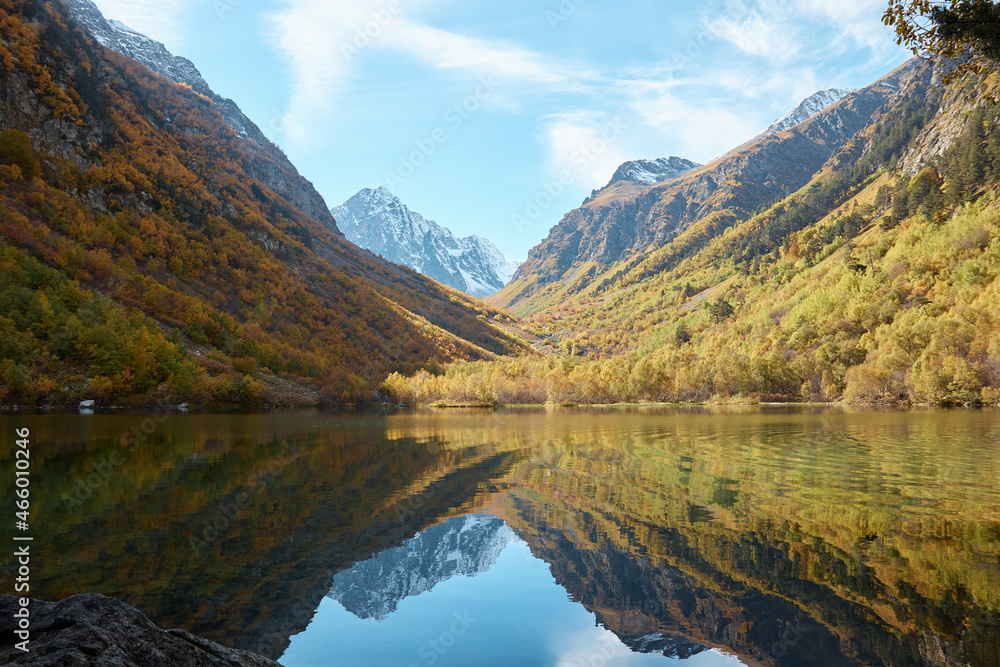 Lake in the mountains, autumn mountain landscape, forest and mountain slopes in autumn colors, water and tranquility