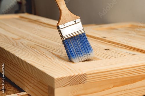 Painting a wooden surface with a brush