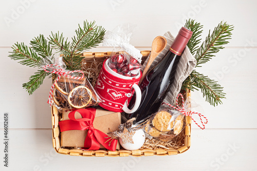 Fotografija Refined Christmas gift basket for culinary enthusiats with bottle of wine and mulled wine ingredients