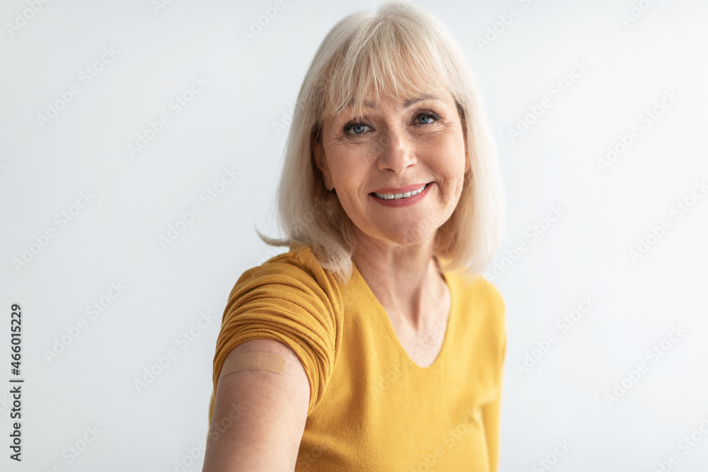 Vaccinated Mature Lady Showing Arm With Plaster On Gray Background Vaccinated Mature Lady Showing Arm With Plaster On Gray Background