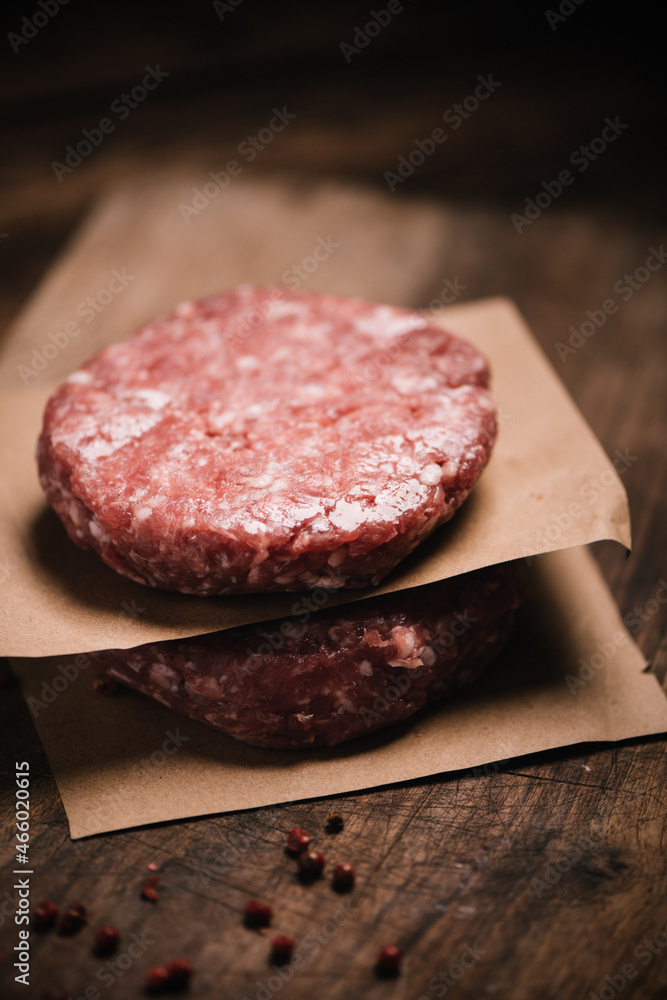 Burger steak cutlets ready to prepare on rustic table Burger steak cutlets ready to prepare on rustic table