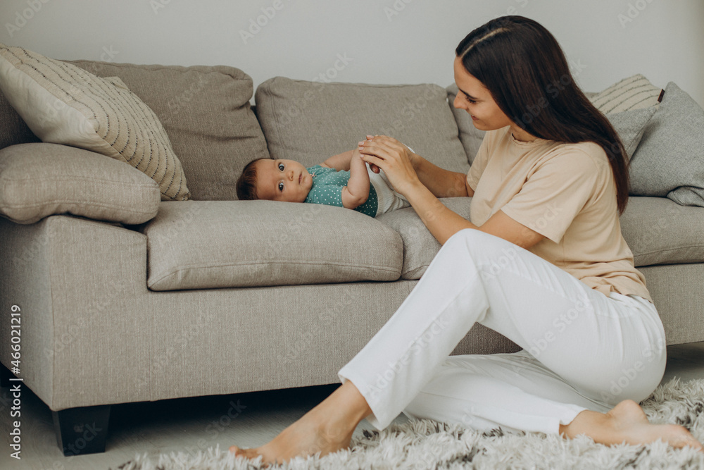 Obraz premium Mother with baby girl on sofa at home