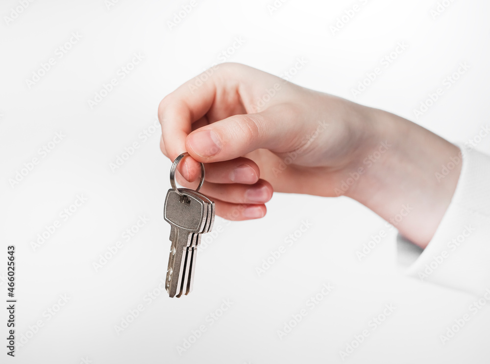 Hand holding keys on keyring over white background. Hand holding keys on keyring over white background.