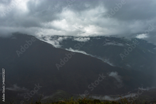 misty mountains with dramatic cloudy sky at morning in rainy day