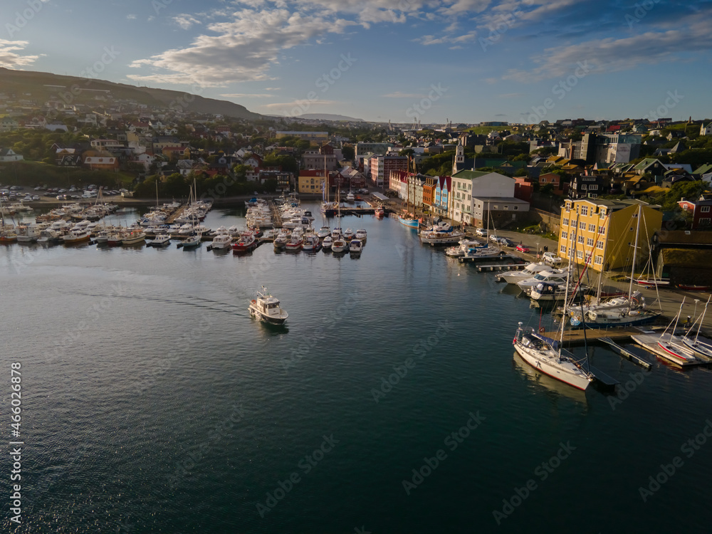 Beautiful aerial view of the City of Torshavn Capital of Faroe Islands- View of Cathedral, colorful buildings, marina, suburbs and Flag