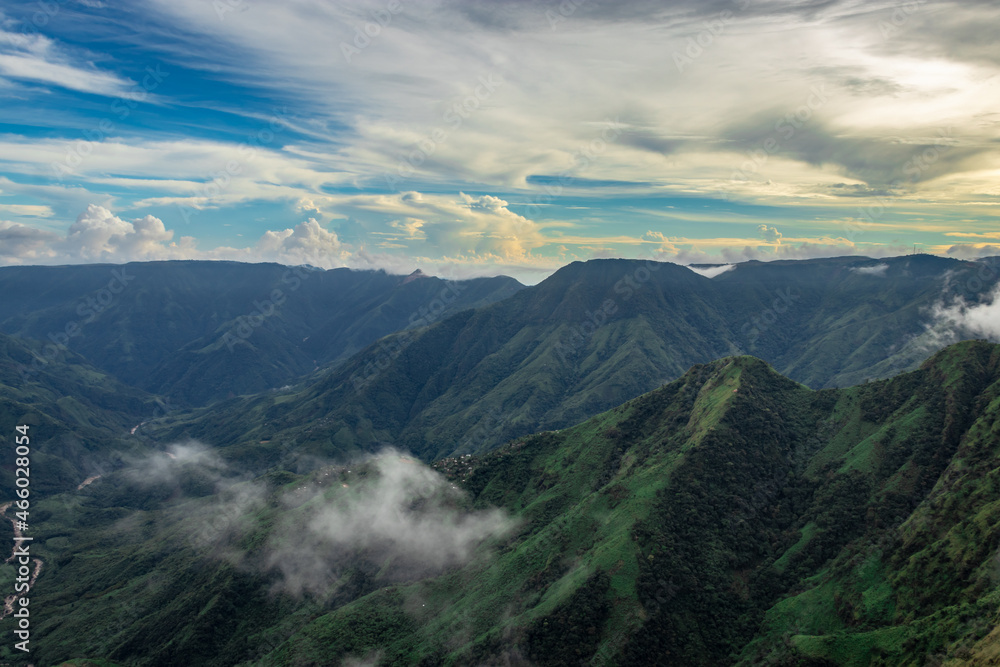 mountain valley with dramatic sunset sky and low clouds at evening mountain valley with dramatic sunset sky and low clouds at evening