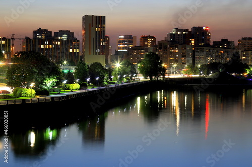 Scenic view of beautiful modern buildings  skyscrapers and towers of night big city are reflected in the Dnieper River in evening. Dnipro  Dnepropetrovsk  Ukraine