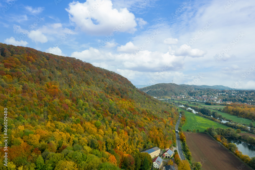 Aerial drone view on autumn colorful mountain landscape. Mountains forest on blue cloudy sky background in october, Germany.