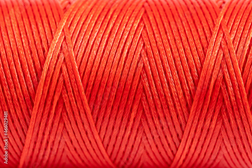 A coil of red thread. Spool of colored threads on a white background. Waxed sewing thread for leather crafts.