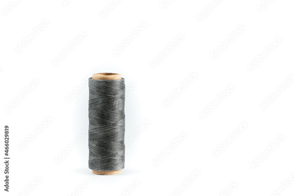 A coil of gray thread. Spool of colored threads on a white background. Waxed sewing thread for leather crafts. A coil of gray thread. Spool of colored threads on a white background. Waxed sewing thread for leather crafts.
