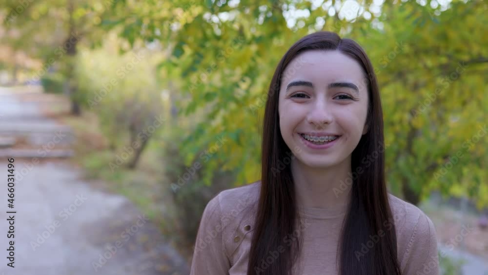 Teenager girl with braces laughing and smiling looking around and at the camera outside. Slow motion 4k Teenager girl with braces laughing and smiling looking around and at the camera outside. Slow motion 4k