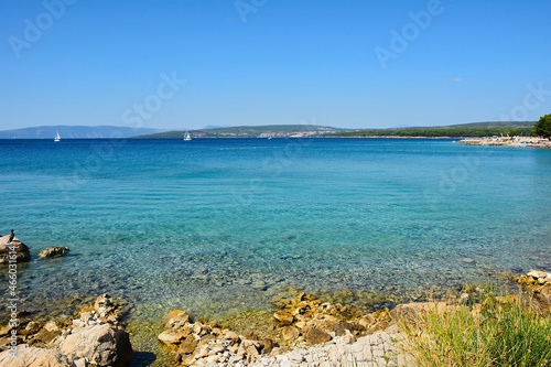 The late summer coastline near to Punat on Krk Island in Primorje-Gorski Kotar County in western Croatia. A cormorant can be seen on the rocks on the left 