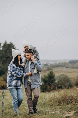 Family with little daughter together in autumnal weather having fun
