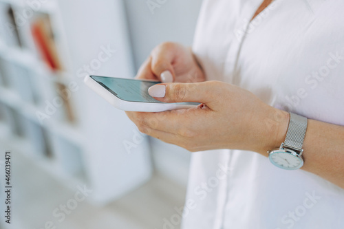 close-up image of women's hands using a smartphone during the day on a city street. Concept search or social networks, bloggers.