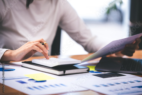 businessman or accountant who are using a calculator to calculate business data Accounting documents and laptop computer at the office business idea