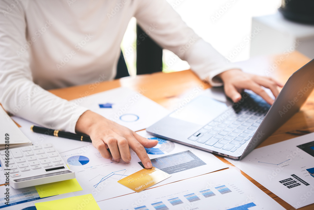 girl holding a credit card and using a laptop Business woman working from home . online shopping, ecommerce, internet banking, spend money, work from home concept. girl holding a credit card and using a laptop Business woman working from home . online shopping, ecommerce, internet banking, spend money, work from home concept.