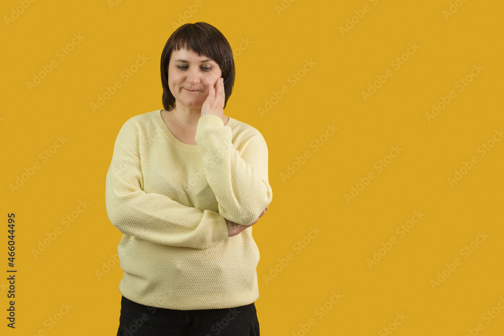 woman sadly stands on yellow background woman sadly stands on yellow background
