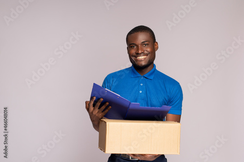 handsome black delivery worker holding a package and a manifest