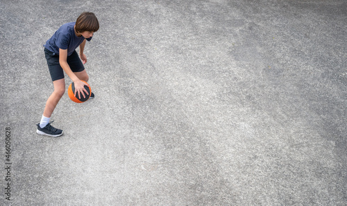 Mixed Race Teenage Boy Practicing Dribbling with Basketball from Above with Copy Space