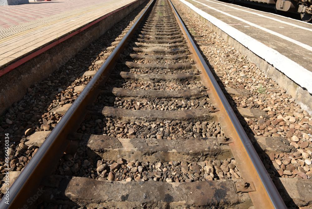 Background of a railway with metal rails and concrete sleepers near the station platform Background of a railway with metal rails and concrete sleepers near the station platform