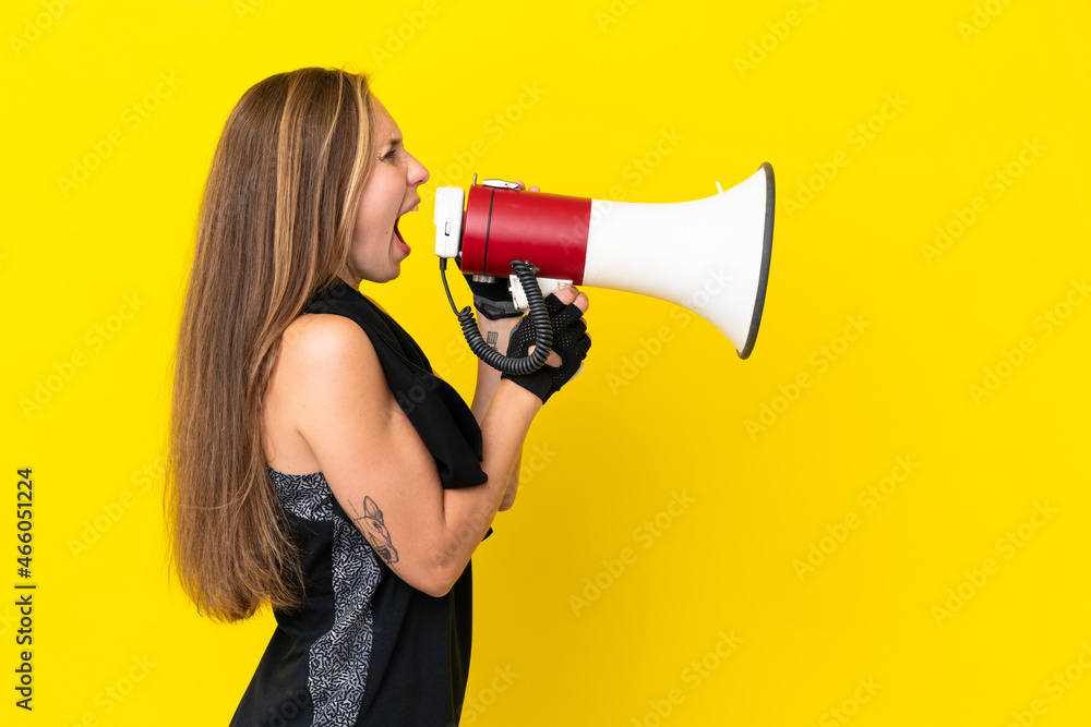 Young sport English woman isolated on white background shouting through a megaphone