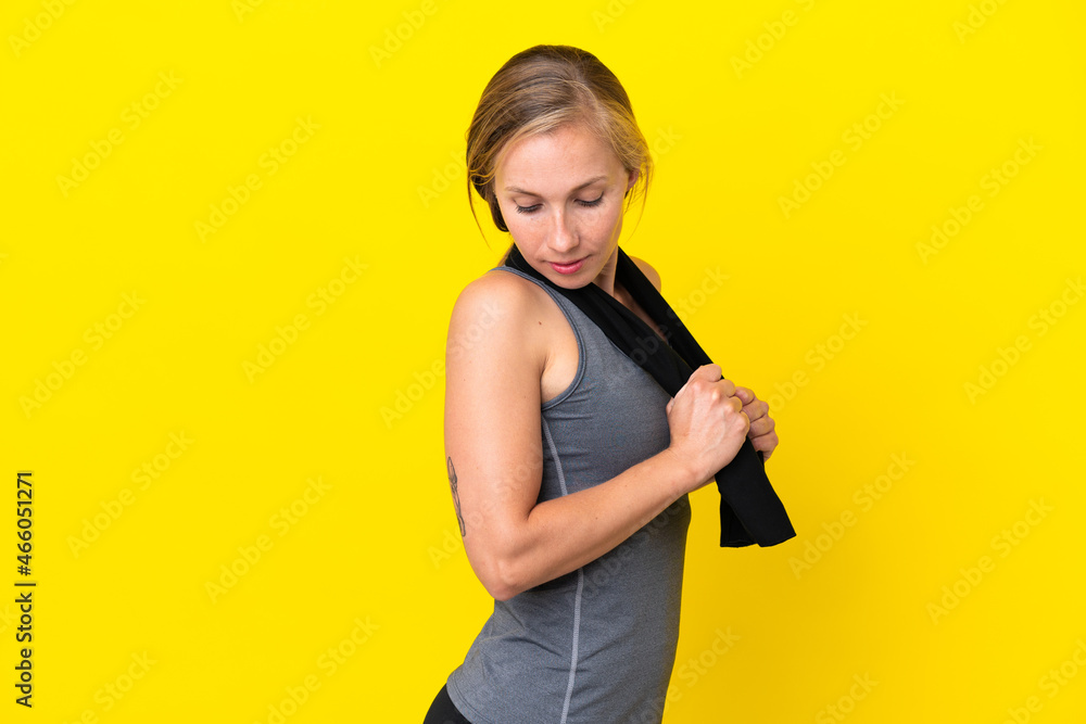 Young English woman isolated on yellow background with sport towel Young English woman isolated on yellow background with sport towel