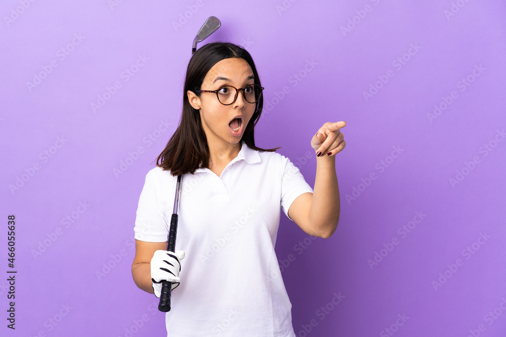 Young golfer woman over isolated colorful background pointing away Young golfer woman over isolated colorful background pointing away