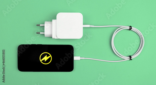 Charging cable for mobile phone. Modern charger adaptor for smartphone. Mint background, flat lay and top view photo