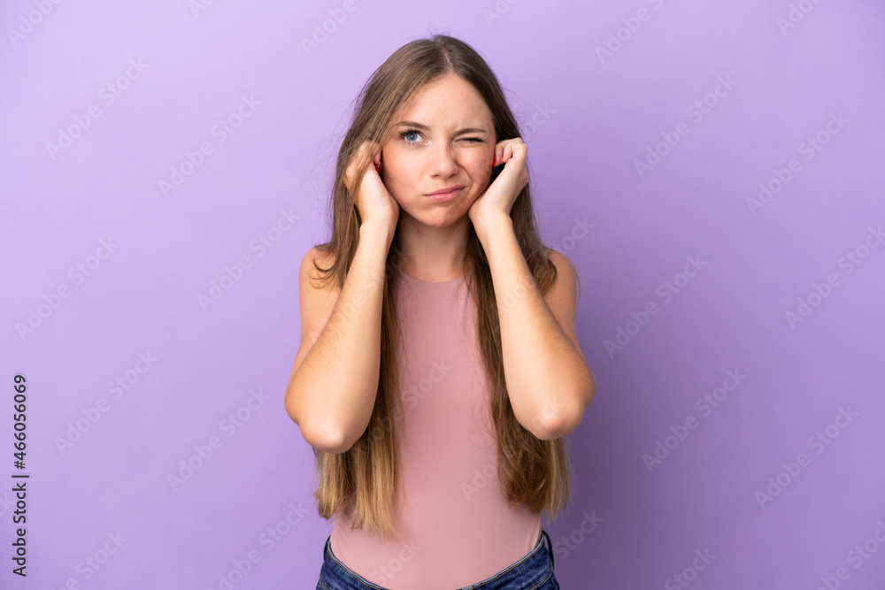 Young Lithuanian woman isolated on purple background frustrated and covering ears
