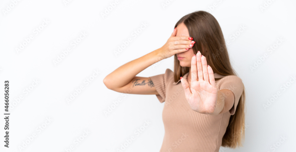 Young Lithuanian woman isolated on white background making stop gesture and covering face Young Lithuanian woman isolated on white background making stop gesture and covering face