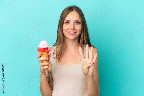 Young Lithuanian woman with cornet ice cream isolated on blue background happy and counting four with fingers