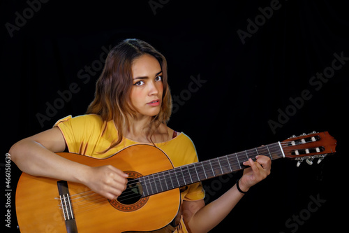 beautiful latin woman playing guitar at studio