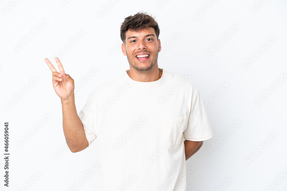Young caucasian handsome man isolated on white background smiling and showing victory sign Young caucasian handsome man isolated on white background smiling and showing victory sign