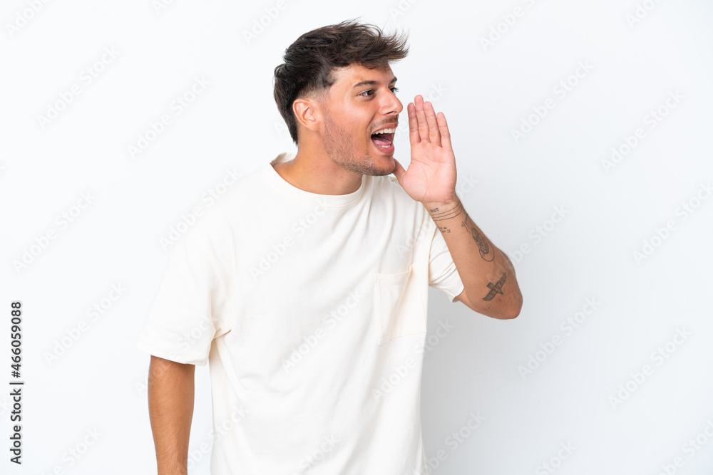 Young caucasian handsome man isolated on white background shouting with mouth wide open to the side Young caucasian handsome man isolated on white background shouting with mouth wide open to the side