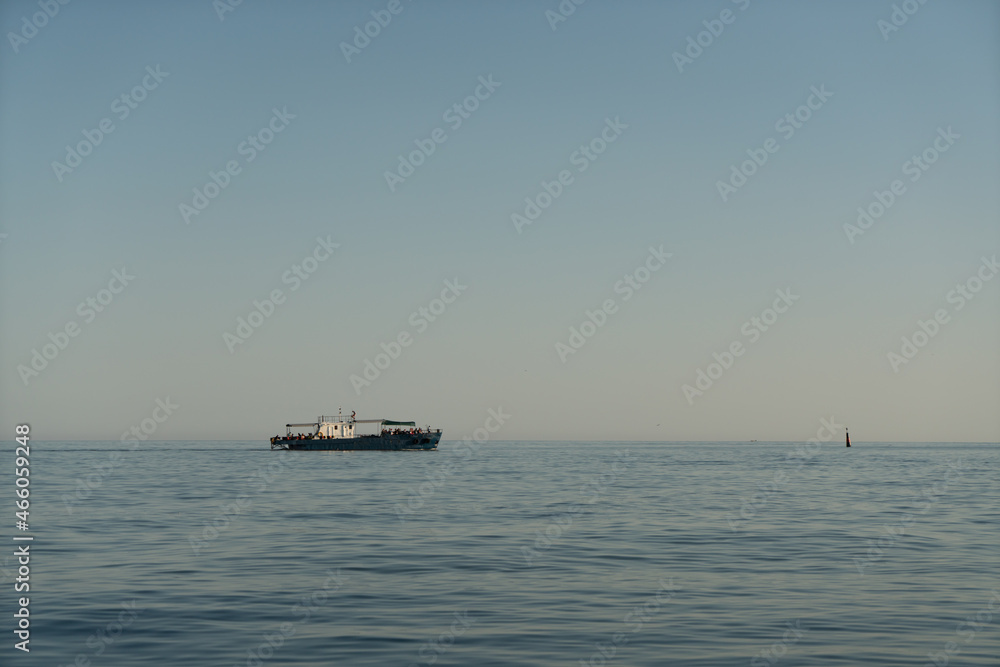 Small marine boat in the sea on the horizon at sunrise. Small marine boat in the sea on the horizon at sunrise.